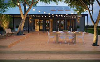 ProWood Color-Treated Wood Deck with Modern House and String Lights Over Dining Table