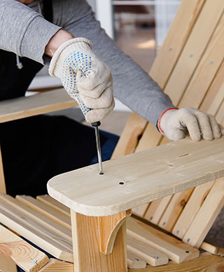 Man Building Wood Adirondack Chair with Screwdriver