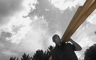 Man Carrying ProWood Lumber Over Shoulder